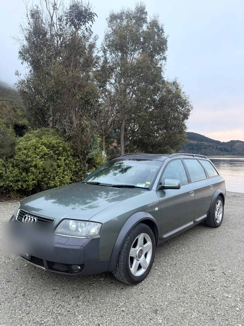 Audi allroad wagon parked beside a lake at dusk